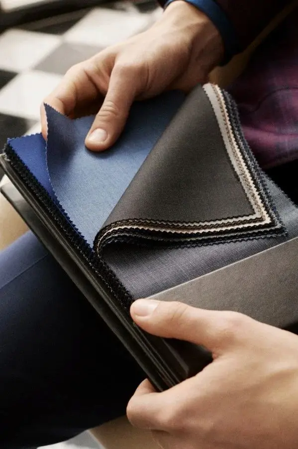 Close-up of luxury fabric swatches and tailoring materials.